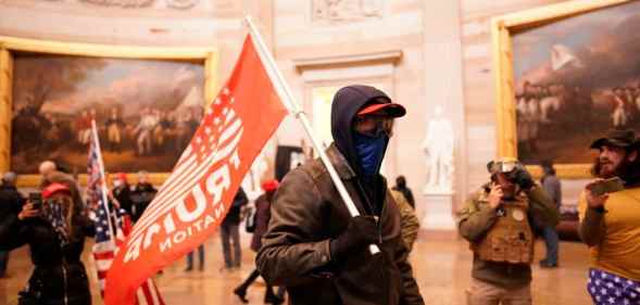 Protester holds a Trump flag during violent insurrection at US Capitol