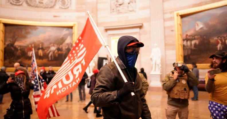 Protester holds a Trump flag during violent insurrection at US Capitol