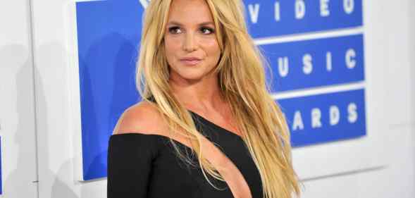 Britney Spears turns to the right in a black dress