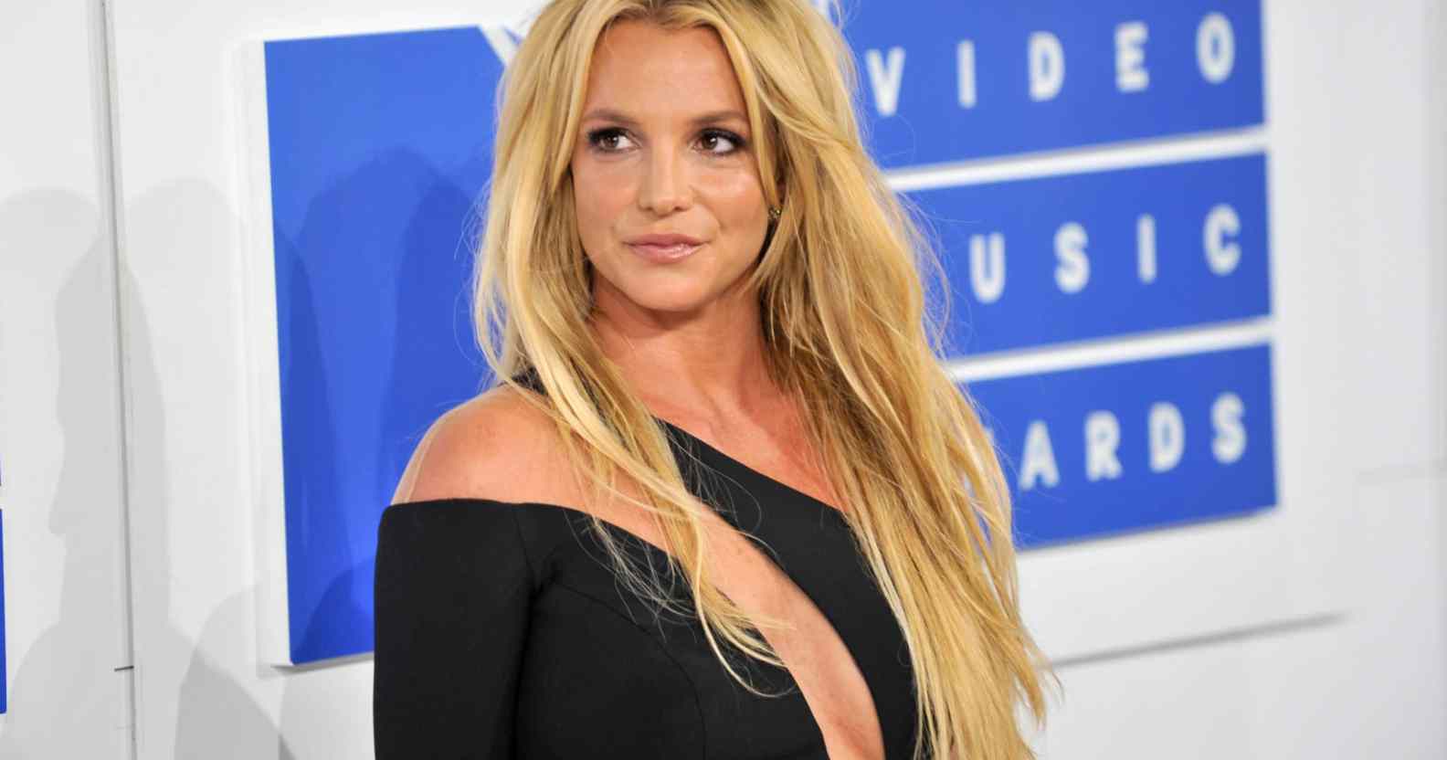 Britney Spears turns to the right in a black dress