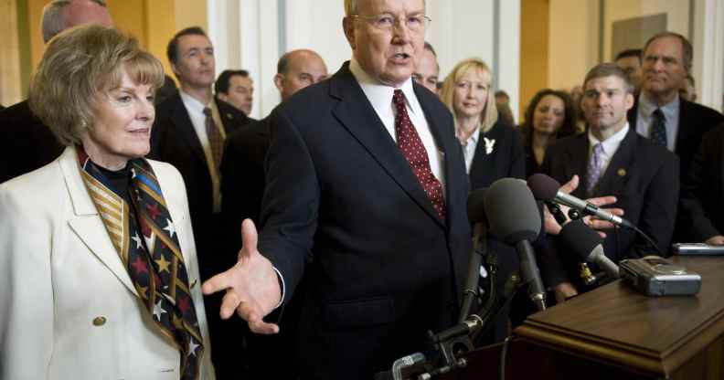 James Dobson in a red tie and black suit standing by his wife Shirley Dobson (L)