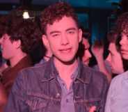 Olly Alexander surrounded by friends in a bar