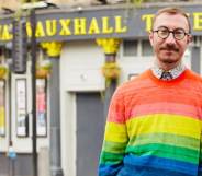 Philip Normal wearing a rainbow jumper standing outside the Royal Vauxhall Tavern