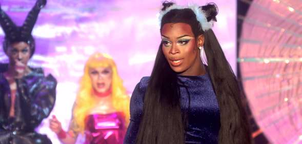 Asttina Mandella in a navy high-necked top with her hair in long ponytails