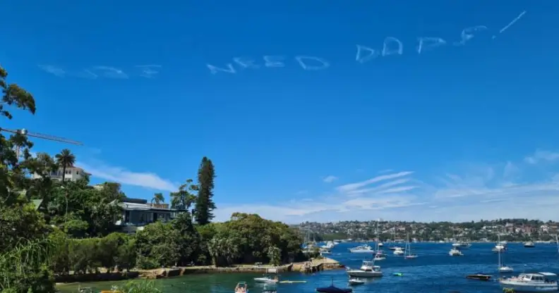 message in aky above sydney Australia that says "kids need dads"