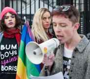 LGBT protestors, one wearing a 'bum boys against Boris' t-shirtm another holding a rainbow Pride flag