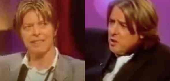 (L) David Bowie in a grey suit smiling. (R) Jonathan Ross in a black suit mid-speaking,