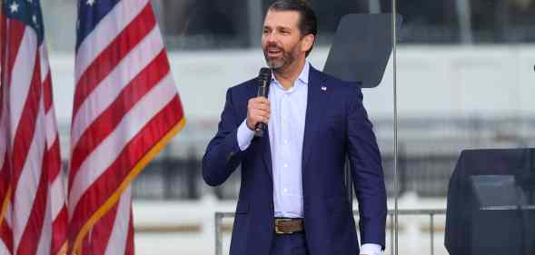 Donald Trump Jr speaking in front of American flags