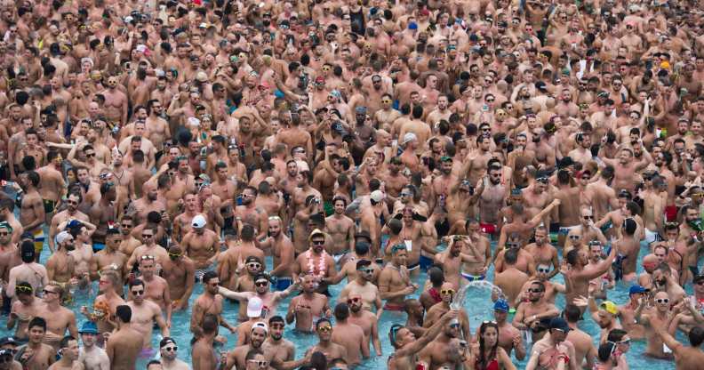 Dozens of men in a pool at a circuit party