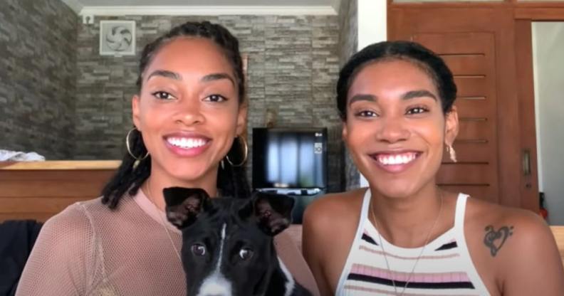 Kristen Gray and Saundra Alexander smile tot he camera with their dog