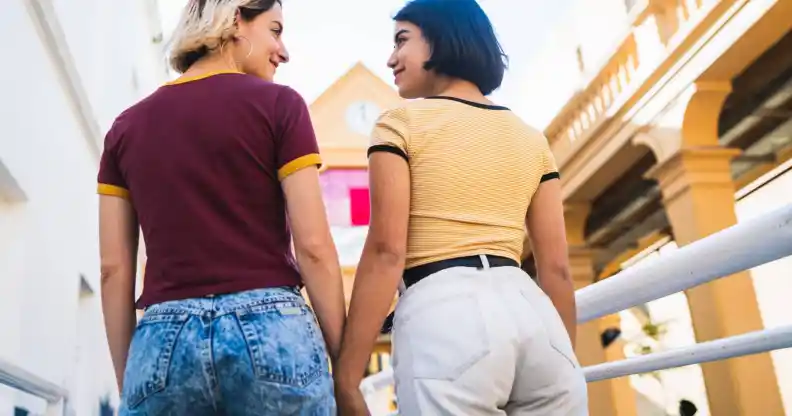 Portrait of lovely lesbian couple spending time together and holding hands at the street