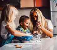 A mother and children playing on the kitchen aisle