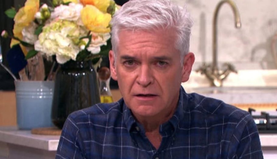 Philip Schofield looks unsettled at the camera while wearing a dark print shirt