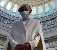 Lady Gaga in a white sheath cape and face mask, the rotunda of the Capitol complex framing her like a halo,