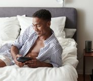 Man lying in bed in boxers and an open shirt holding the Arcwave Ion, a sleek sheath masturbator