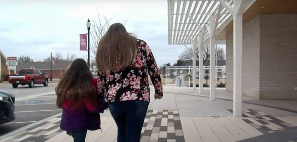 woman and her daughter walking together back portrait