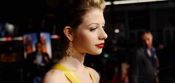 Michelle Trachtenberg in a yellow dress looks away from the camera on the red carpet