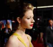 Michelle Trachtenberg in a yellow dress looks away from the camera on the red carpet