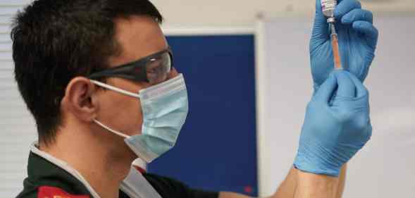 a paramedic draws up the AstraZeneca/Oxford University COVID-19 vaccine