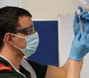 a paramedic draws up the AstraZeneca/Oxford University COVID-19 vaccine