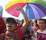 LGBT Activists wearing rainbow colours and holding a rainbow Pride umbrella attend a rally to mark International Women's Day In Indonesia