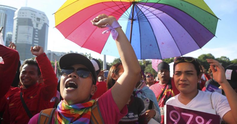 LGBT Activists wearing rainbow colours and holding a rainbow Pride umbrella attend a rally to mark International Women's Day In Indonesia