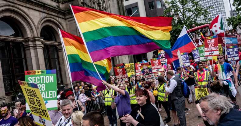 Thousands of members of the LGBTQ community march in the Birmingham Pride parade, holding rainbow flags and signs