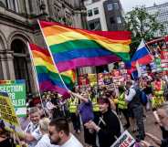 Thousands of members of the LGBTQ community march in the Birmingham Pride parade, holding rainbow flags and signs