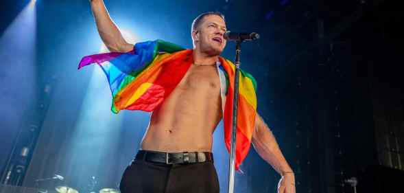 Dan Reynolds of Imagine Dragons holds a gay pride flag