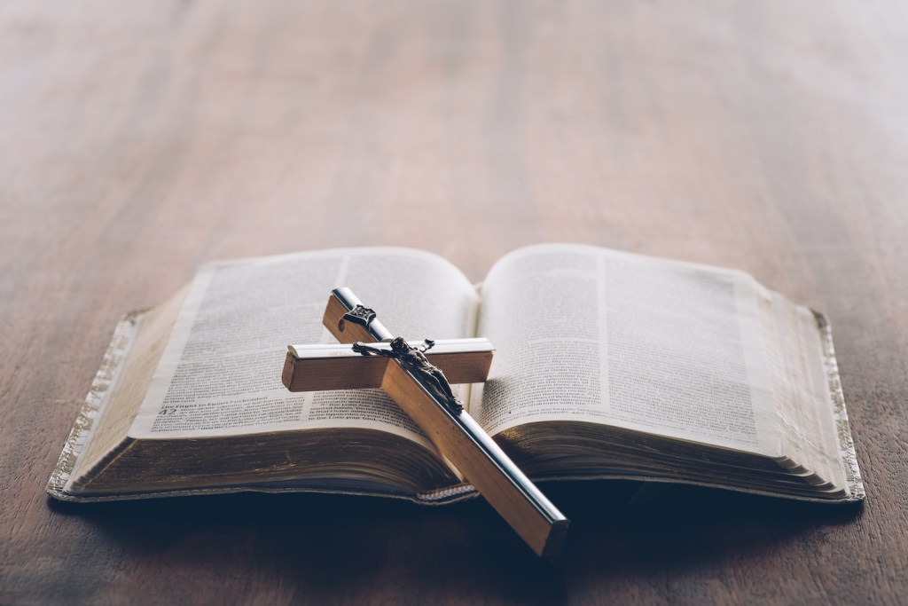 Picture of a bible with a cross lying on it