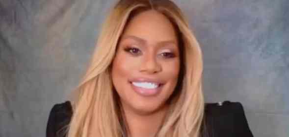 Laverne Cox smiles to the camera in a black top