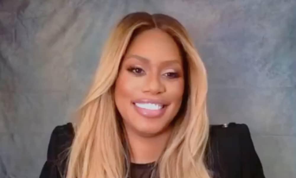 Laverne Cox smiles to the camera in a black top