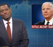 Michael Che hosting Saturday Night Live's "The Weekend Update" with a picture of President Joe Biden in the background with text underneath reading 'repeals military transgender ban'