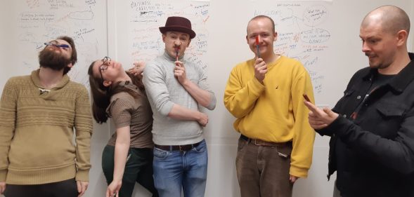 Five people standing in front of a whiteboard