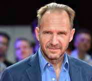 Headshot of Ralph Fiennes wearing a blue shirt and blazer