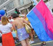 Parade goers with one holding the Bisexual Pride flag during Pride in London 2019