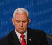 A fly rests on the head of Mike Pence as he takes notes during the vice presidential debate against Kamala Harris