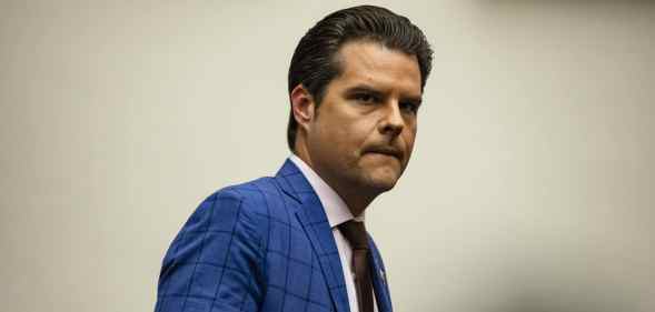 Matt Gaetz looks concerned in a blue plaid suit