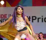 Sinitta dances as she holds her gold cape on the Pride in London main stage