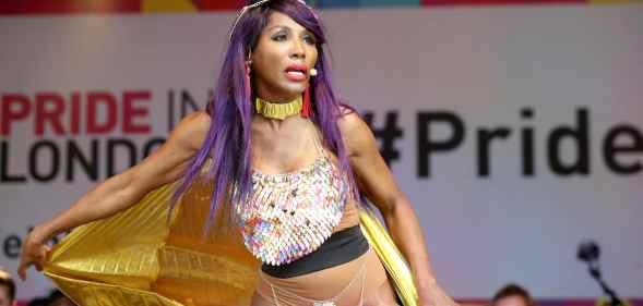 Sinitta dances as she holds her gold cape on the Pride in London main stage