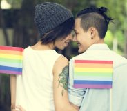LGBT+ couple holding Pride flags