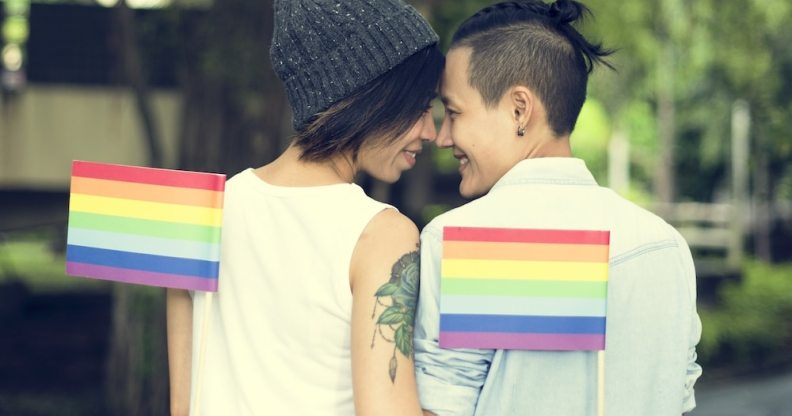 LGBT+ couple holding Pride flags