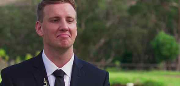 Liam Cooper smirks in a suit against a wooded backdrop