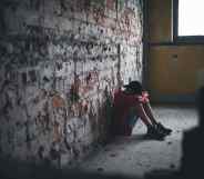 Sad and disappointed teenagers boy sitting indoors in abandoned building