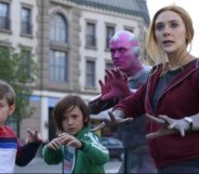 Superheros Wanda and Vision with their two young children, Billy and Tommy, all standing in a street with their hands raised, ready to attack