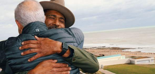 Marc and John hugging, taken over John's shoulder