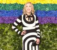 Catherine O'Hara poses in front of a rainbow background