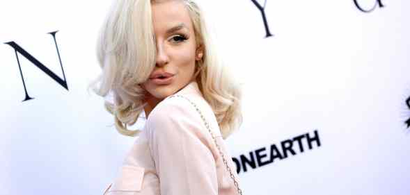 Courtney Stodden poses to the camera on the red carpet in a light pink shirt