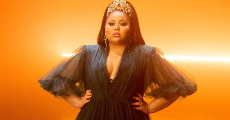 Destiny stands against glowing orange lights with her hands on her waist