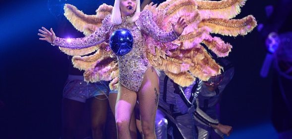 Lady Gaga, wearing a winged costume with a blue ball on her chest, performs onstage during The ARTPOP Ball tour opener